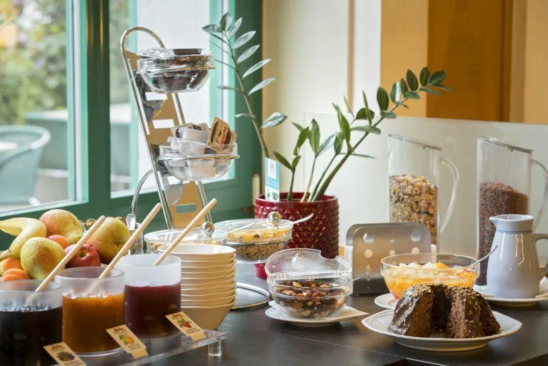 Frühstückstisch mit Gebäck, Obst und Kaffee im Motel Baden