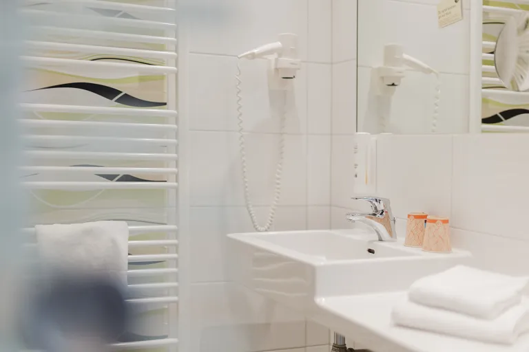 Bathroom with hairdryer and heated towel rail at Motel Baden