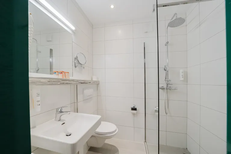 Modern bathroom with walk-in shower, vanity, and WC at Motel Baden