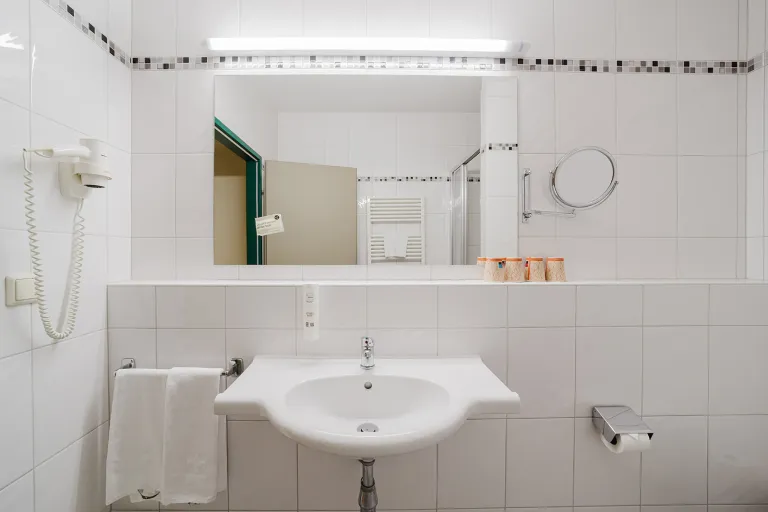 Vanity with large mirror and cosmetic mirror at Motel Baden