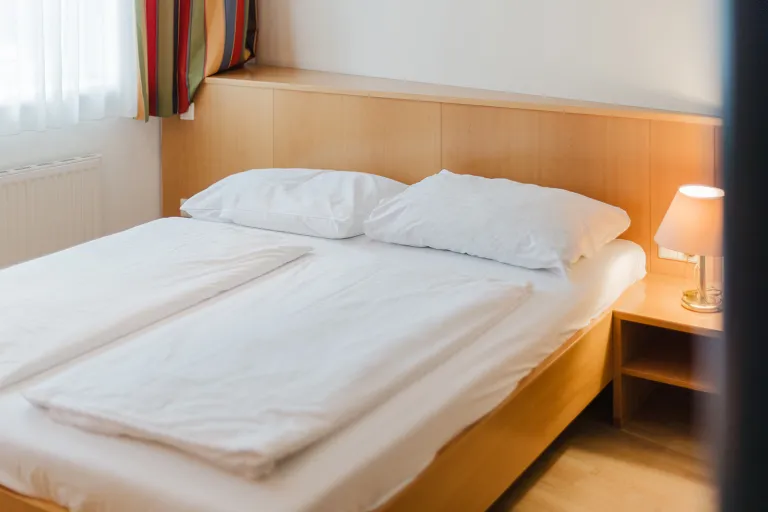 Double bed with bedside lamp at Motel Baden