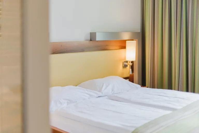 Double bed with curtain at Motel Baden