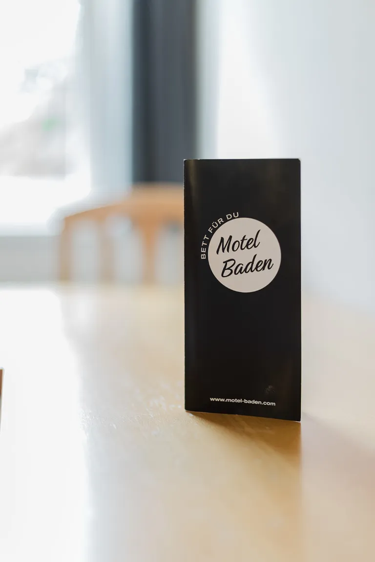 Motel Baden flyer on a table