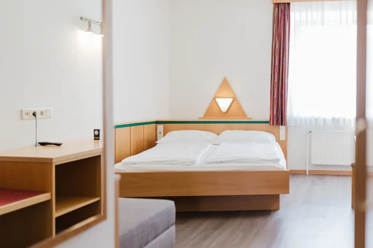 Double bed with triangular lamp at Motel Baden