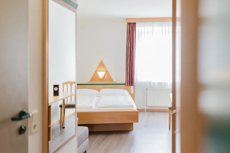 View through the door onto the double bed in the double room with private garage at Motel Baden