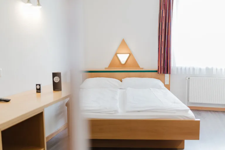 Double bed and desk in the double room with private garage at Motel Baden