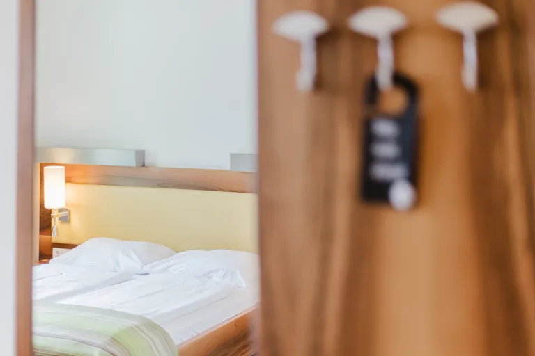 Coat rack with door hanger and bed at Motel Baden