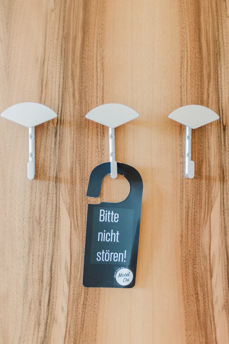 Coat hooks with "Please do not disturb!" door hanger at Motel Baden