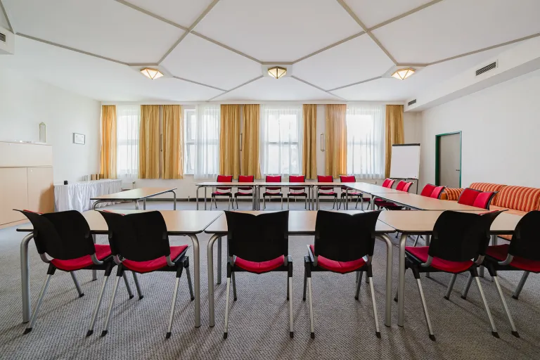 Large seminar room on the 1st floor with red chairs in U-shape at Motel Baden