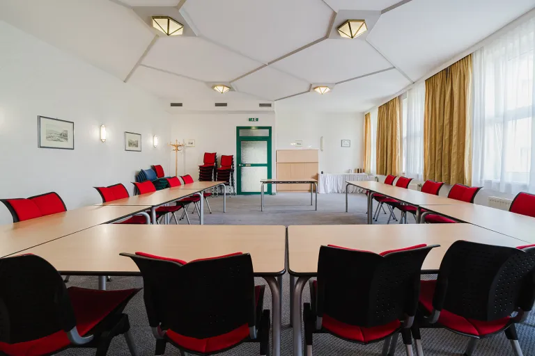 Large seminar room on the 1st floor with tables in U-shape and daylight at Motel Baden