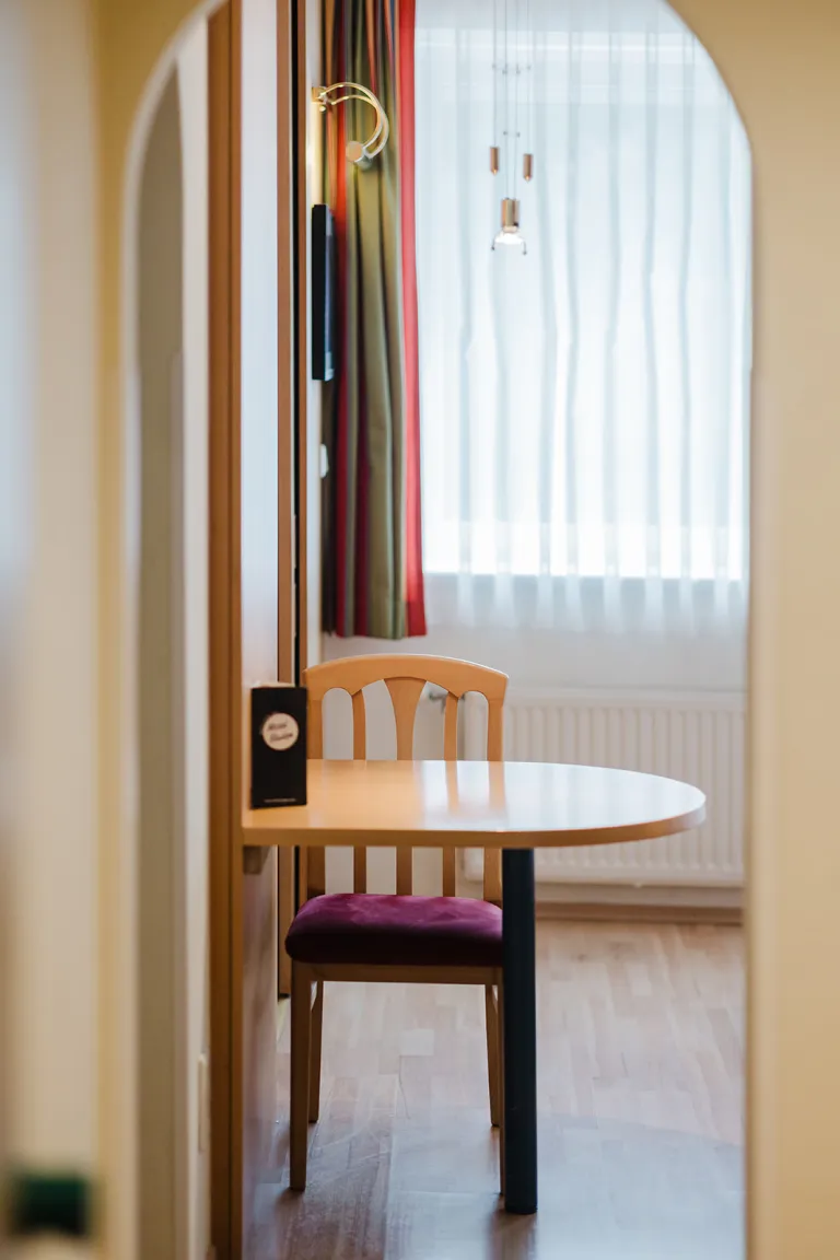 Seating area with table and chair by the window at Motel Baden