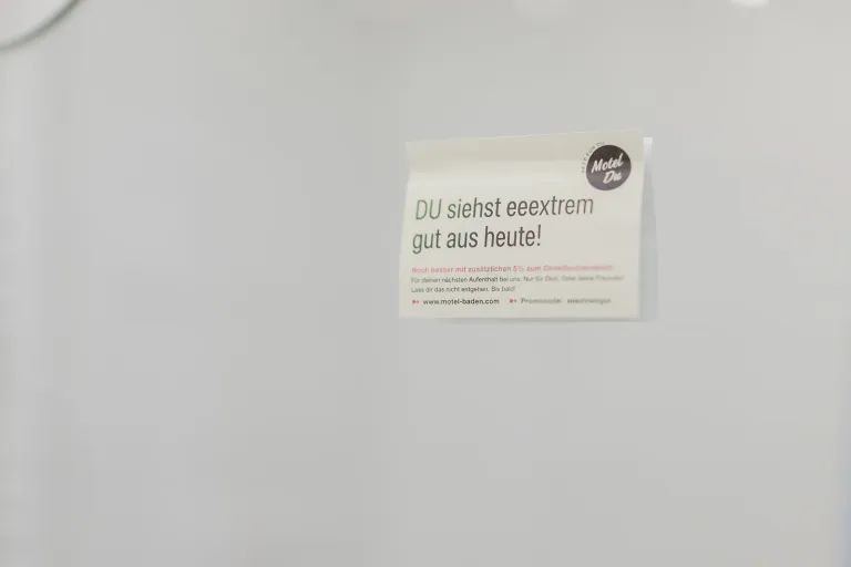 Card "YOU look simply great today!" on the wall at Motel Baden