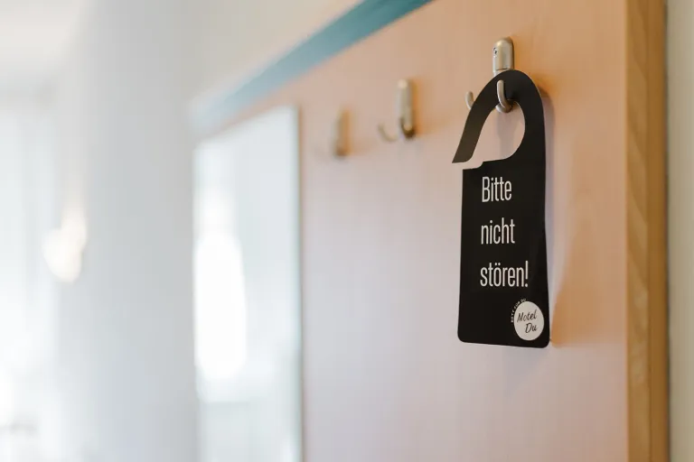 "Please do not disturb!" door hanger on the coat rack at Motel Baden