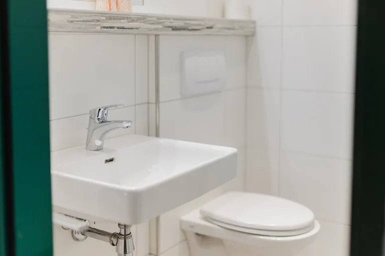 Washbasin and WC in the bathroom at Motel Baden