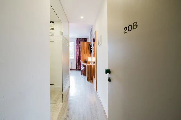 Open door of room 208 with a view into the room at Motel Baden