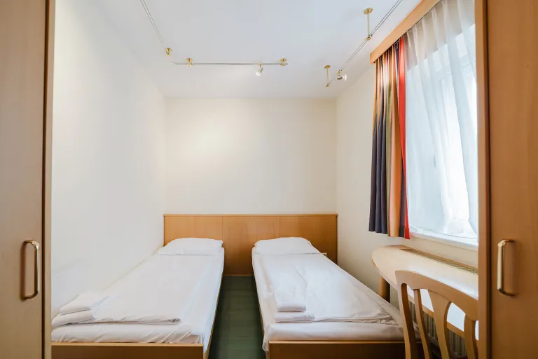 Room with two single beds and window at Motel Baden