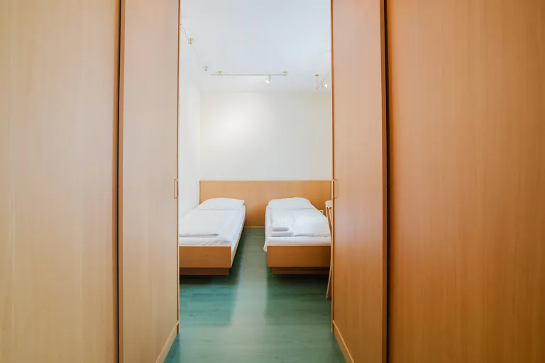 View through the wooden door into a room with two single beds at Motel Baden